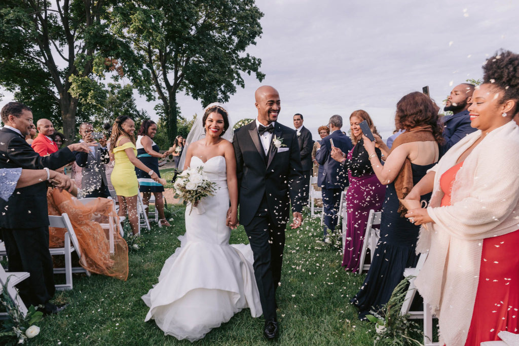 Newlywed couple walks down the aisle to confetti and smiles at this New York wedding on the grounds of the Sands Point Preserve
