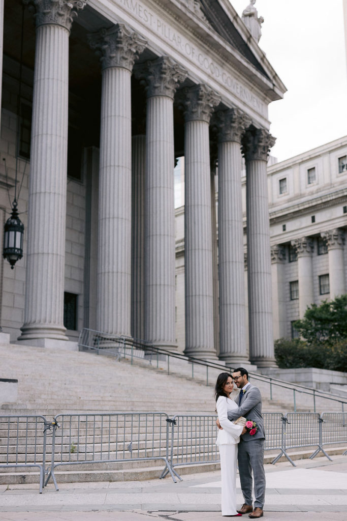 Newlyweds pose on the steps of City Hall in New York City after being married there