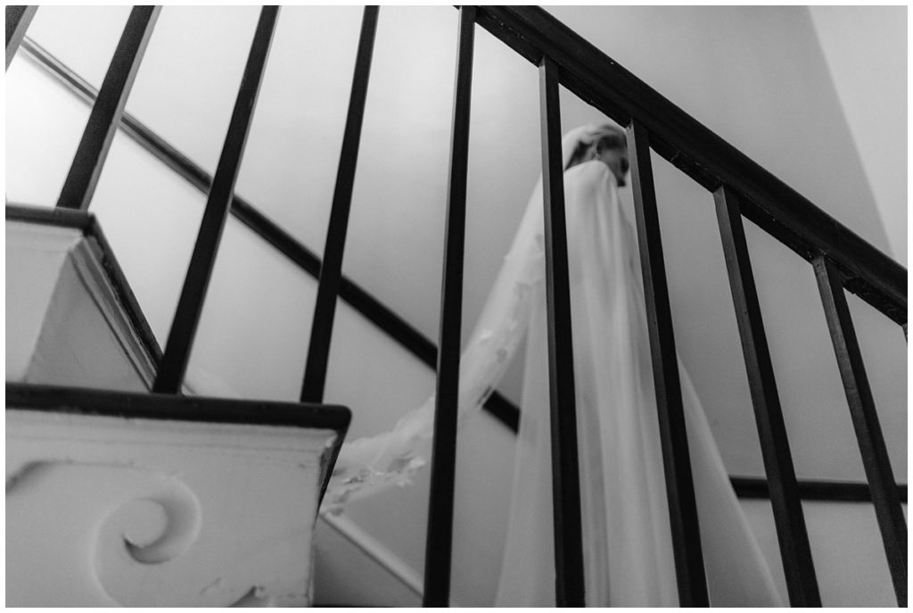 bride comes down the stairs to do her first look