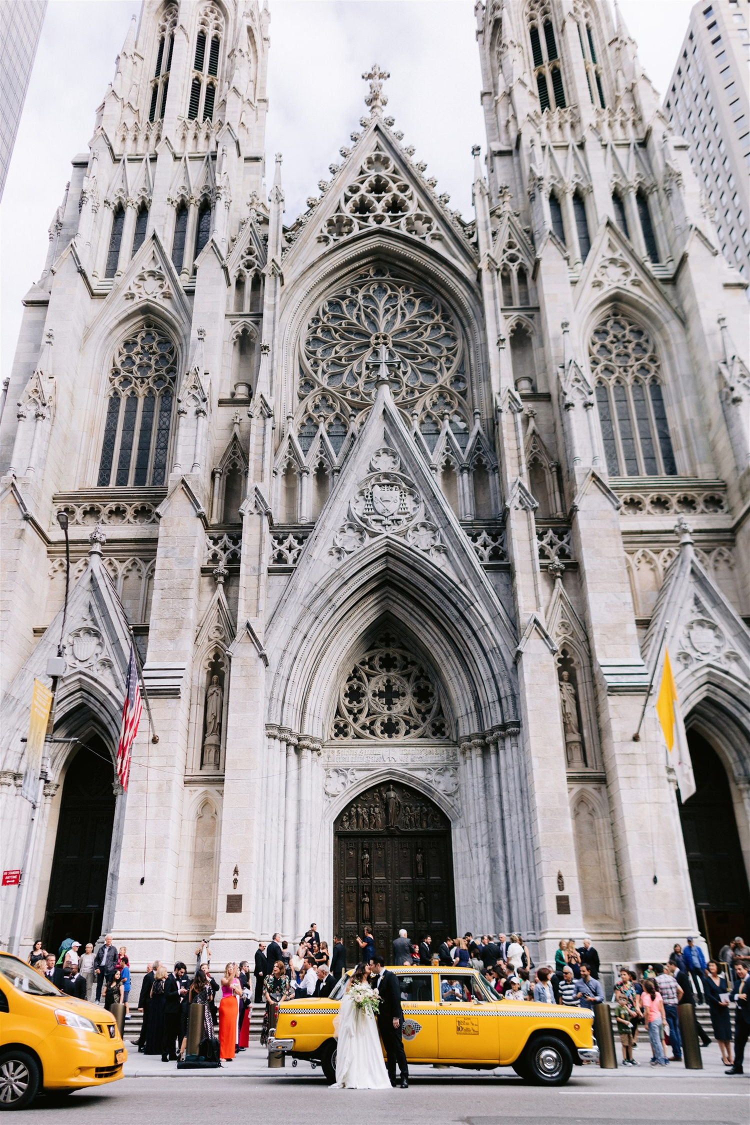 st. patricks cathedral, jw marriott essex house, bridal, wedding, classic new york wedding, bride and groom share a kiss in front of a huge church in Manhattan nyc on 5th ave, fifth avenue, film cars New York, checker cab, Manhattan wedding