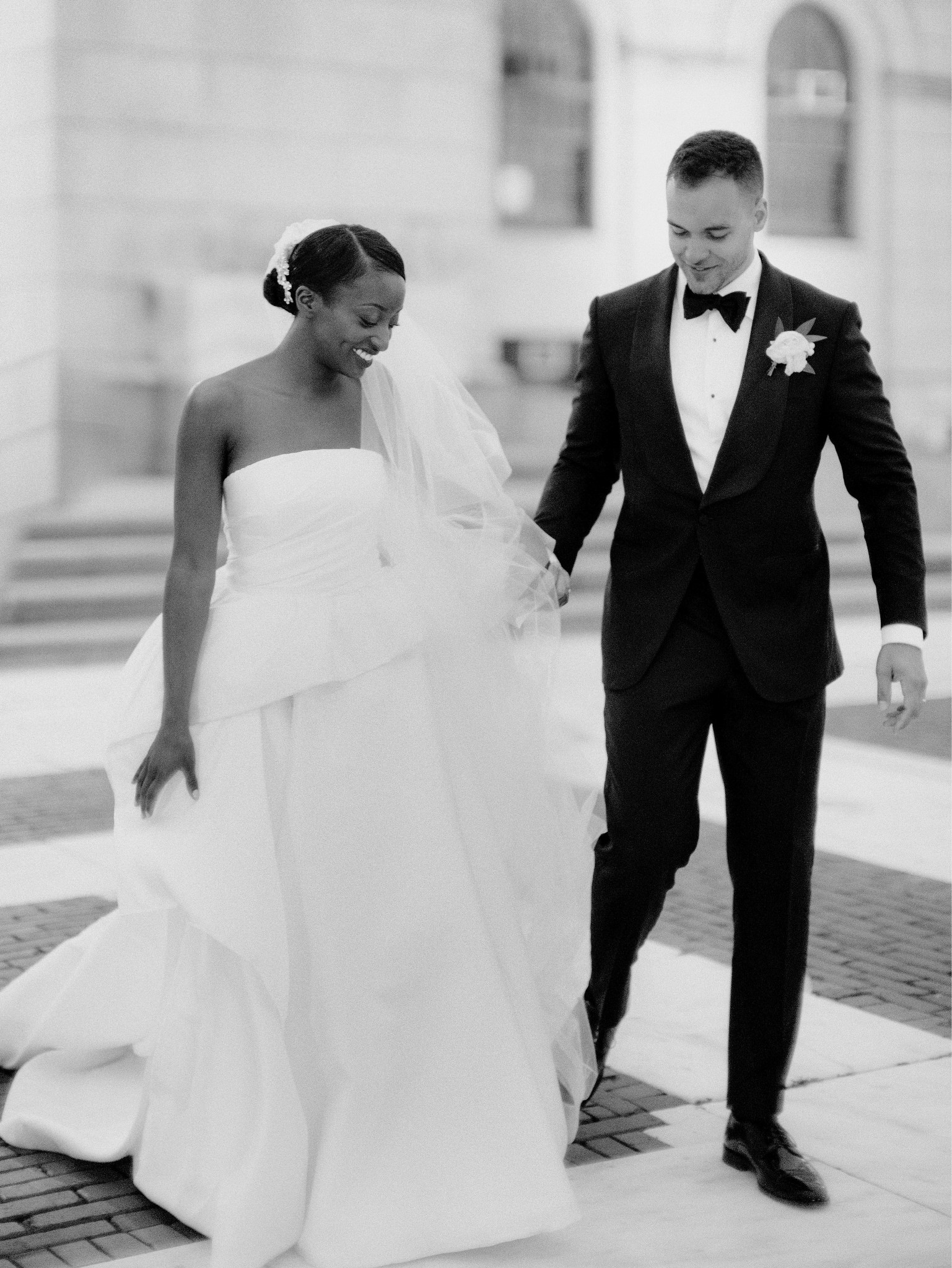 Couple holding hands in wedding dress and suit after ceremony at Providence Public Library