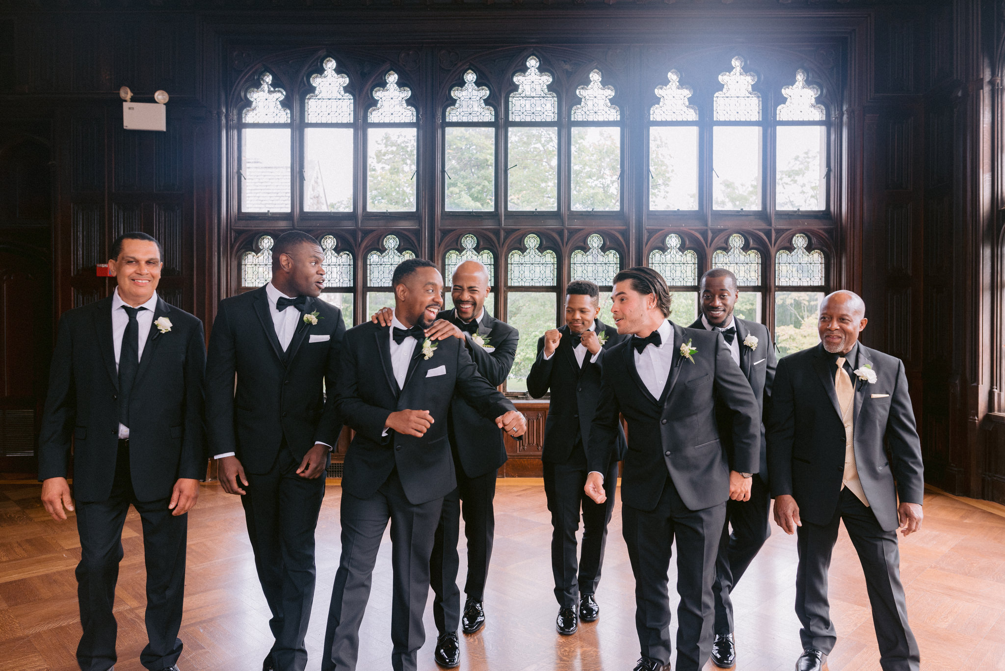 Groomsmen in front of beautiful windows before wedding at Hempstead House