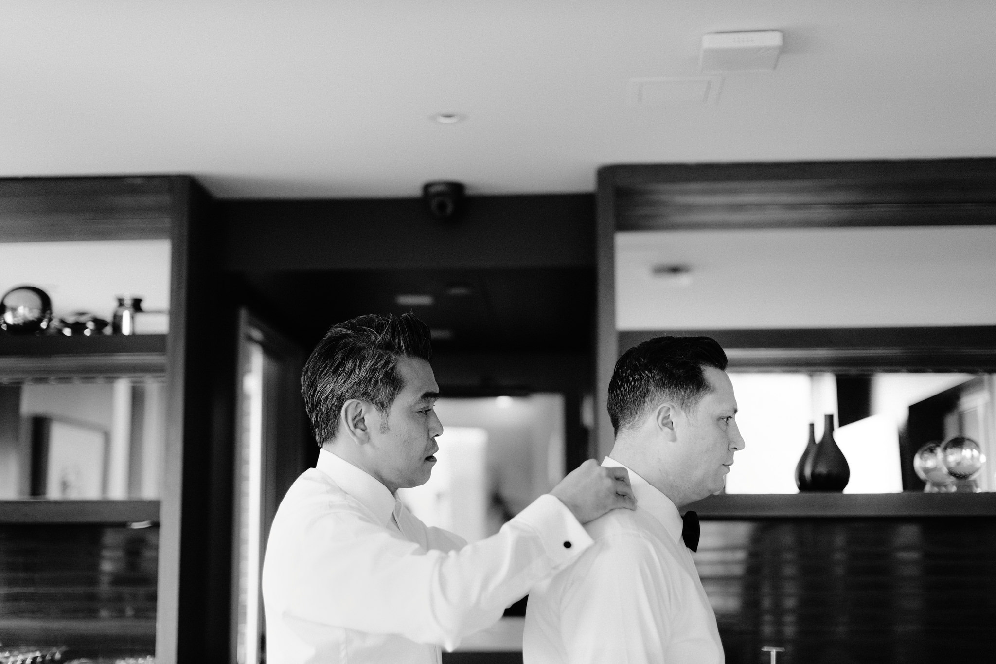 Man fixing partners shirt collar before same sex wedding