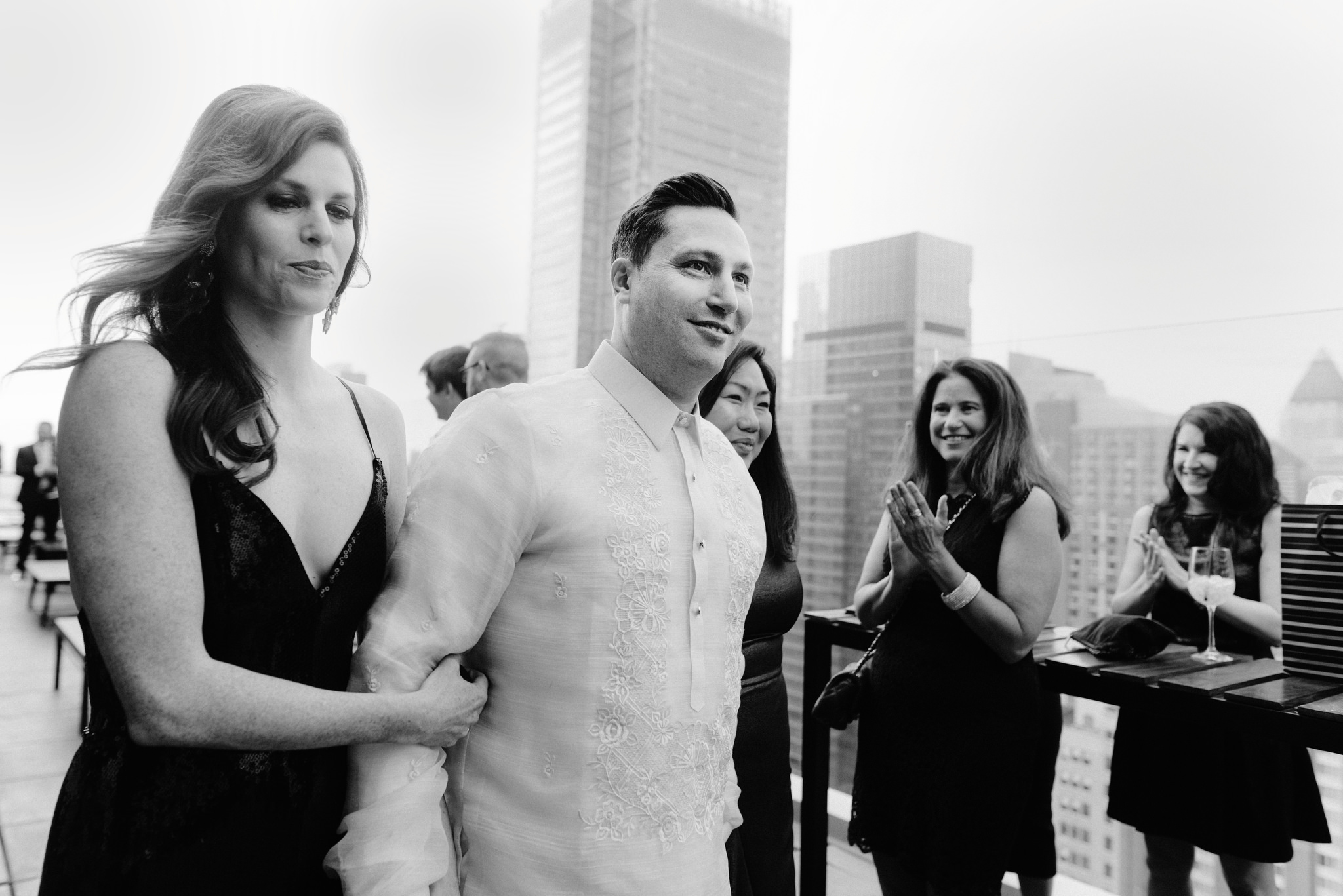 Guests clapping as groom is walked down the aisle by woman on wedding day at the Skylark