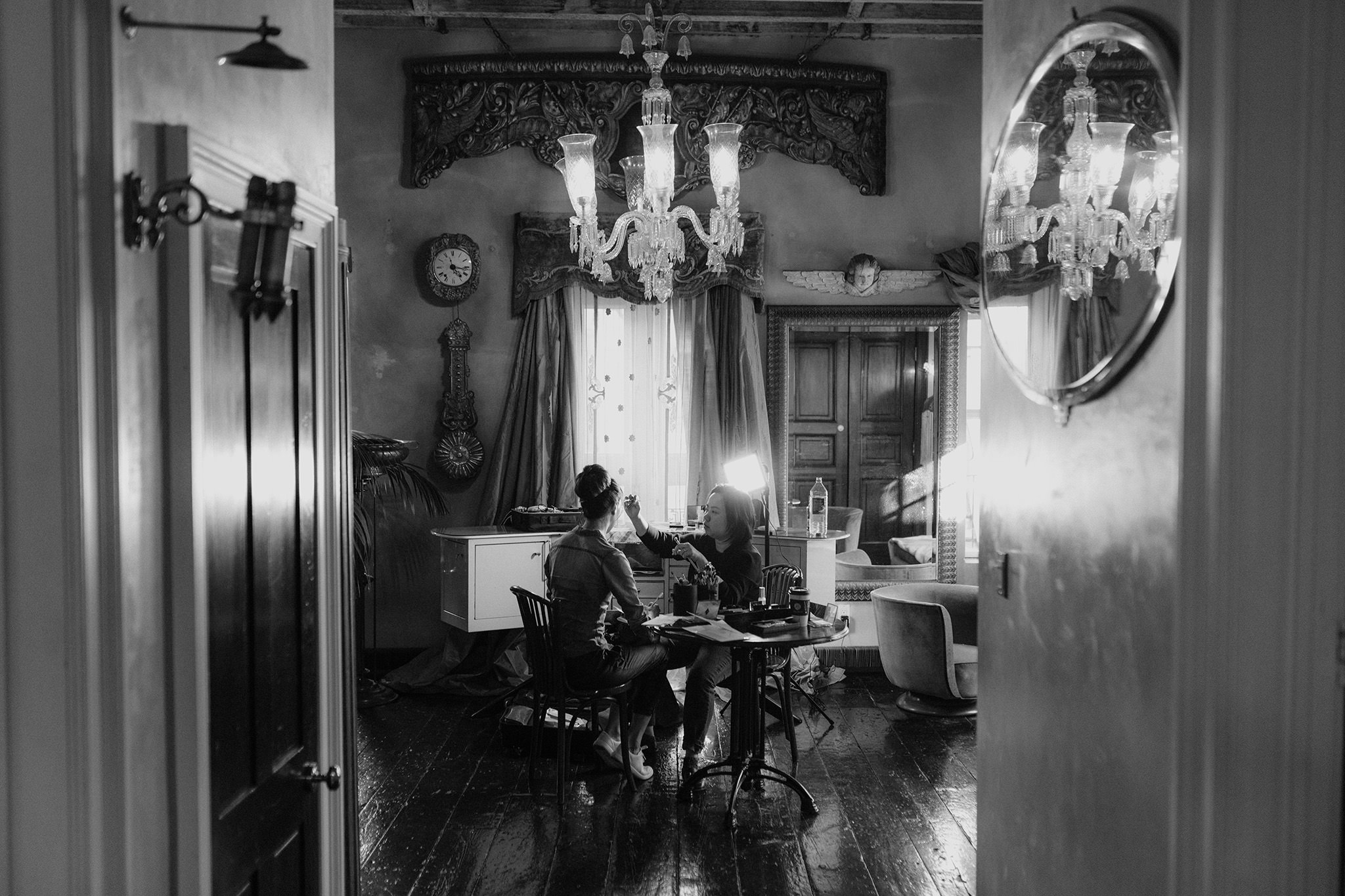 View through doorway of bride getting her makeup done in old character home style room