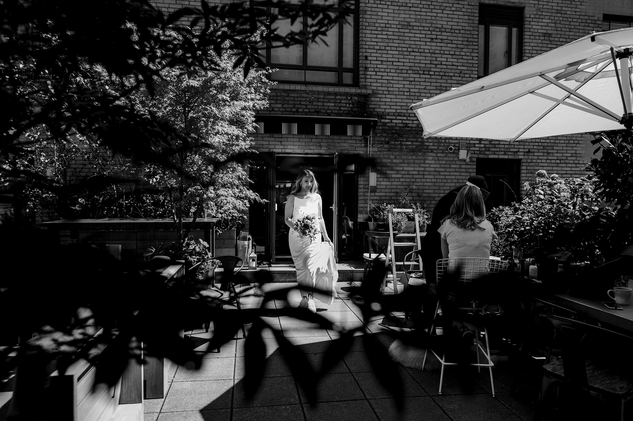 Bride holds her gown and bouquet while walking down the aisle toward her groom