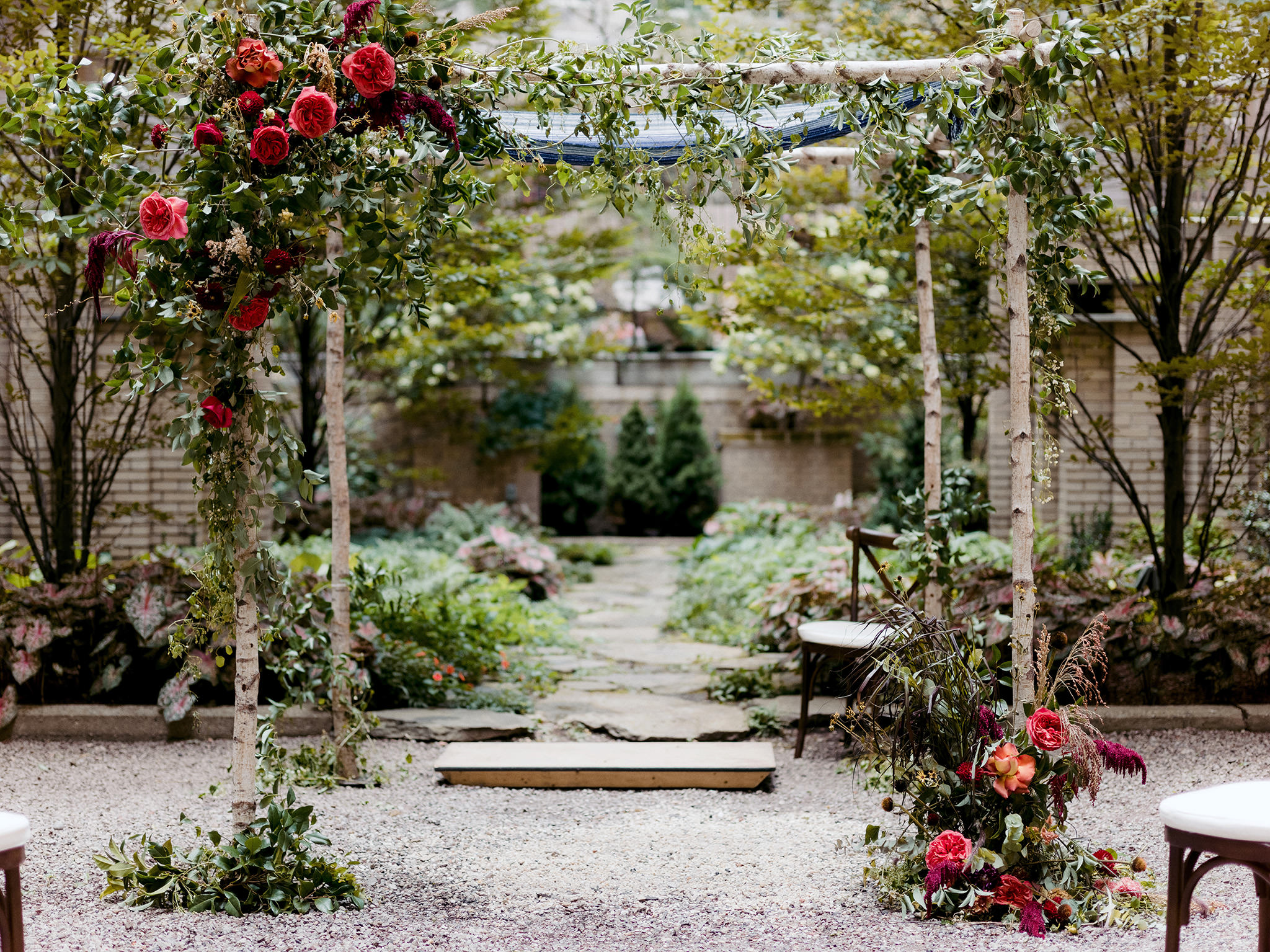 Ceremony archway adorned with pink flowers by Bloom Bar NYC