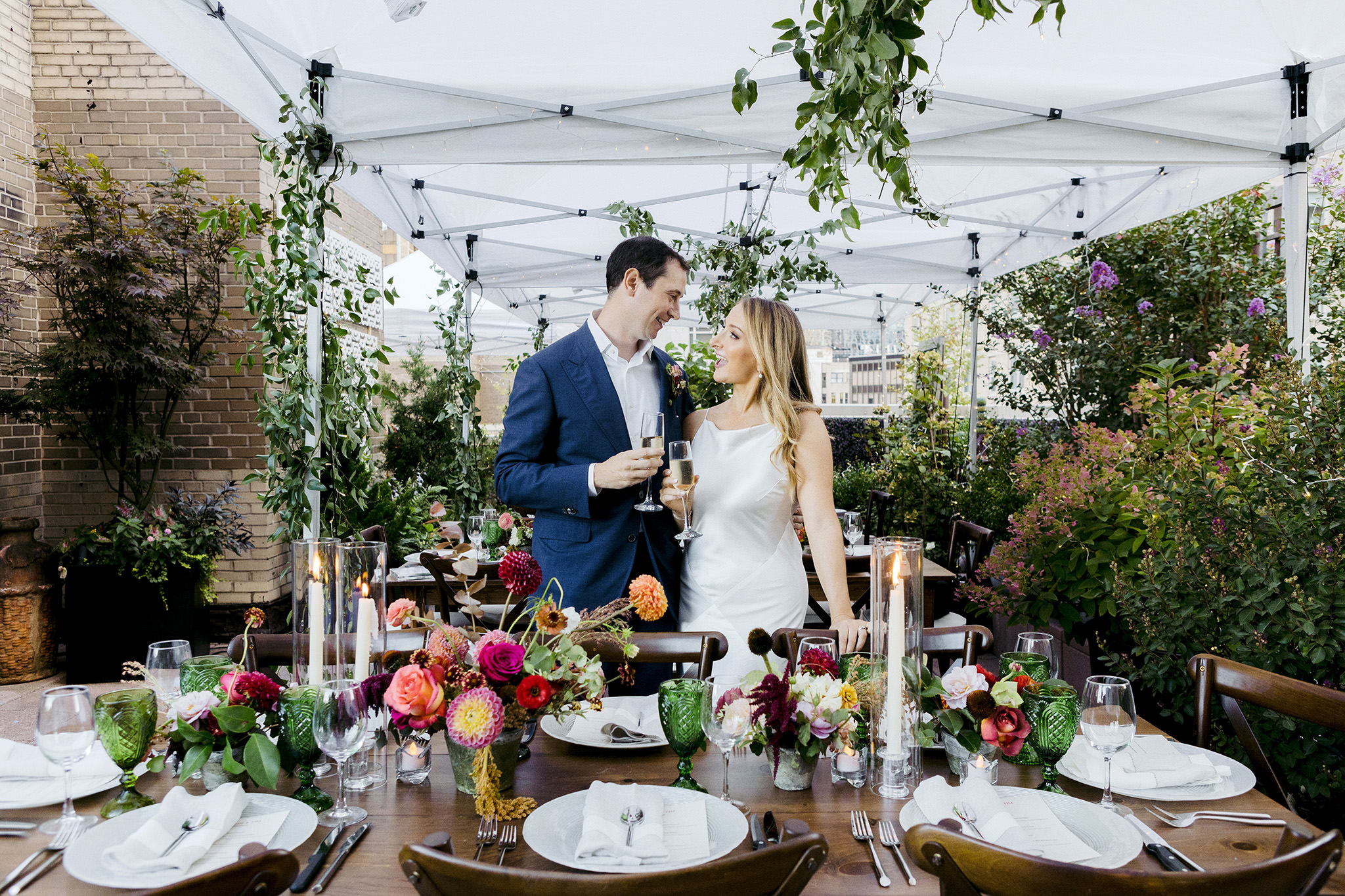 Bride and groom cheers champagne at their reception dinner on the rooftop patio