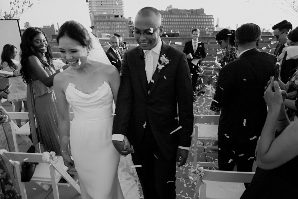 Man and woman walking down the aisle for their first time as husband and wife.