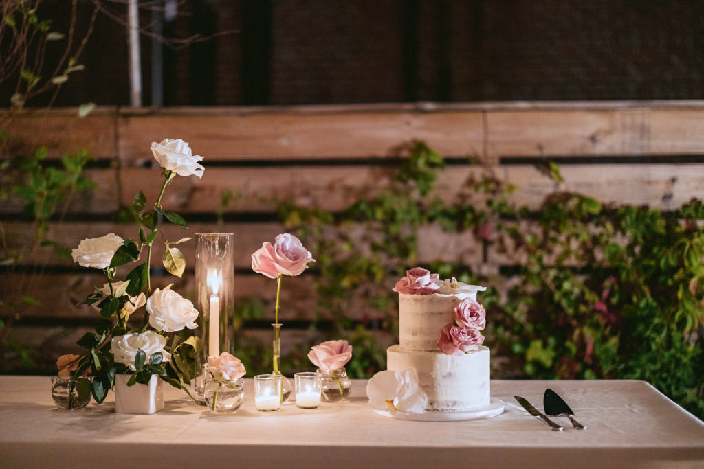 Simple white wedding cake with pink roses for garnish