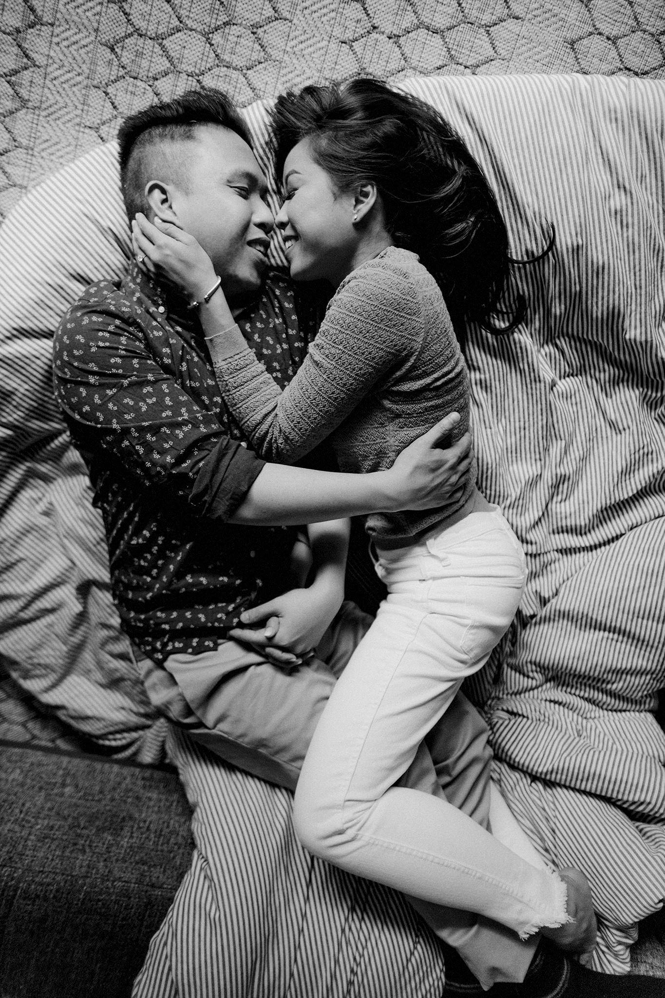 Engaged couple embracing on their couch during an indoor engagement session