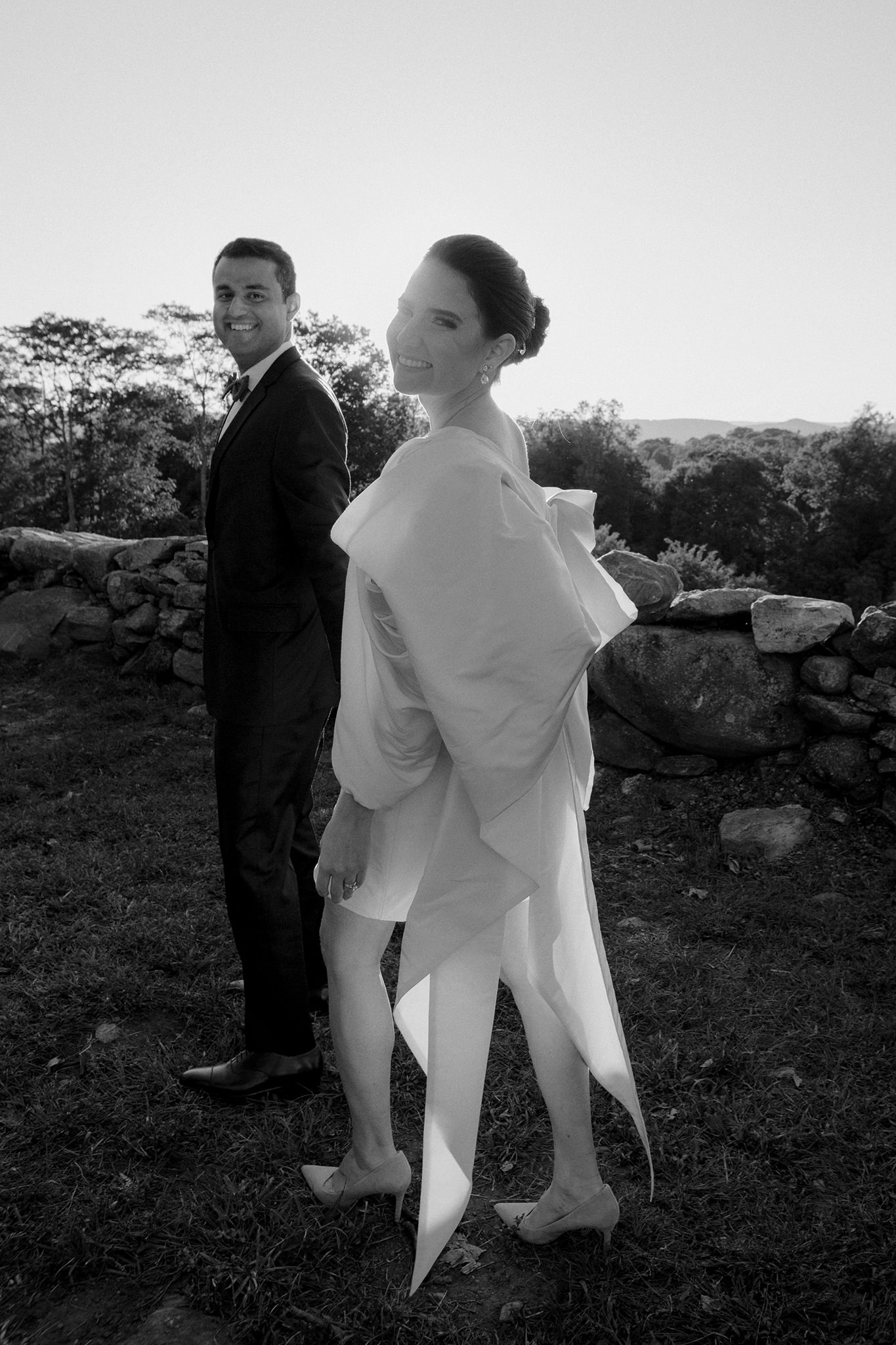 Bride smiling into with the sunset behind her