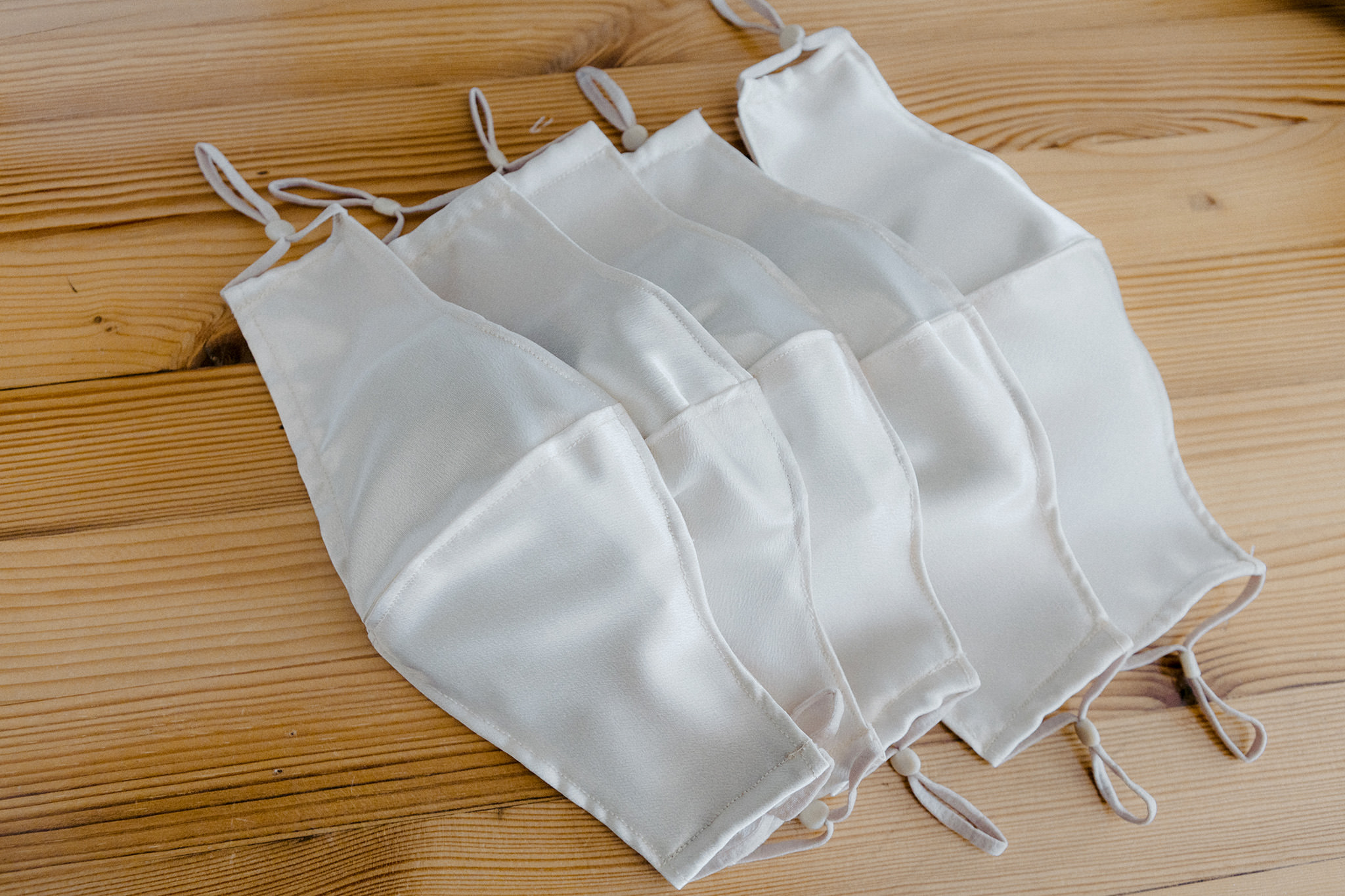 Satin white COVID19 masks sewed by the bride for her bridesmaids during pandemic wedding 2020.