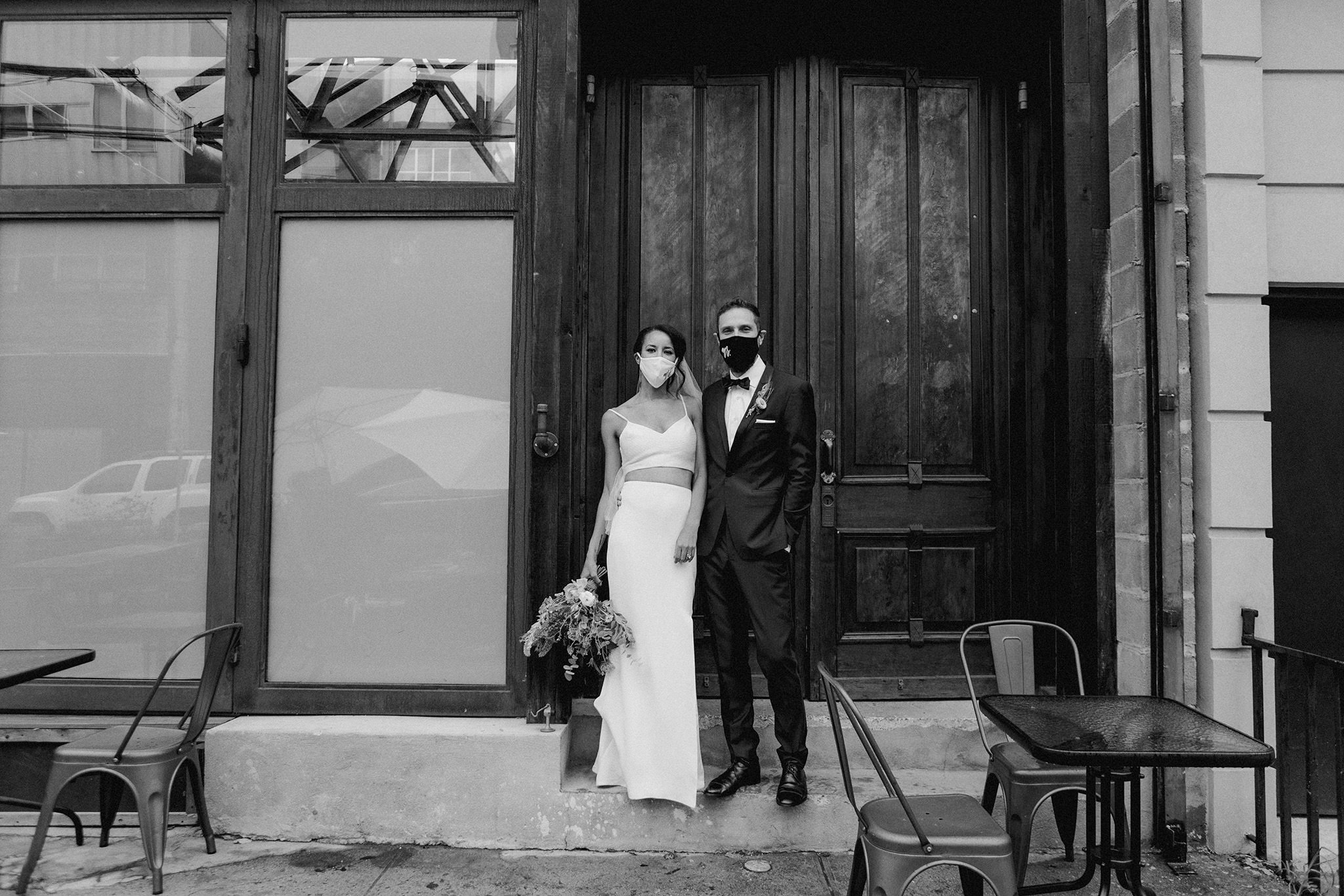 bride and groom just married standing outside Brooklyn winery with masks on