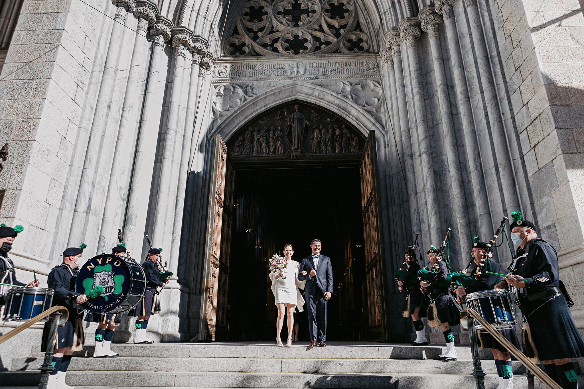 Bride and groom leaving their NYC ceremony with the NYPD Emerald Society playing bagpipes