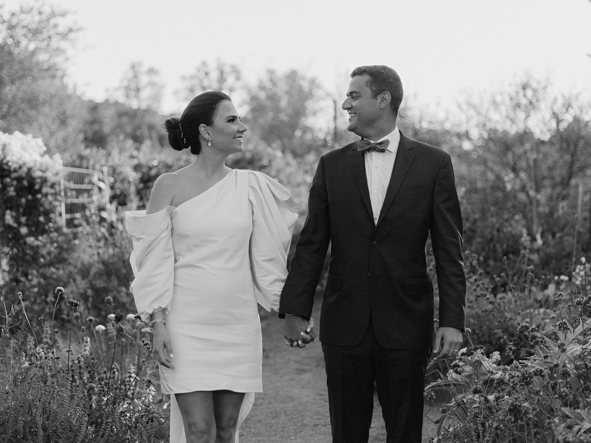 Black and white photo of bride and groom holding hands on wedding day at Blue Hill at Stone Barns