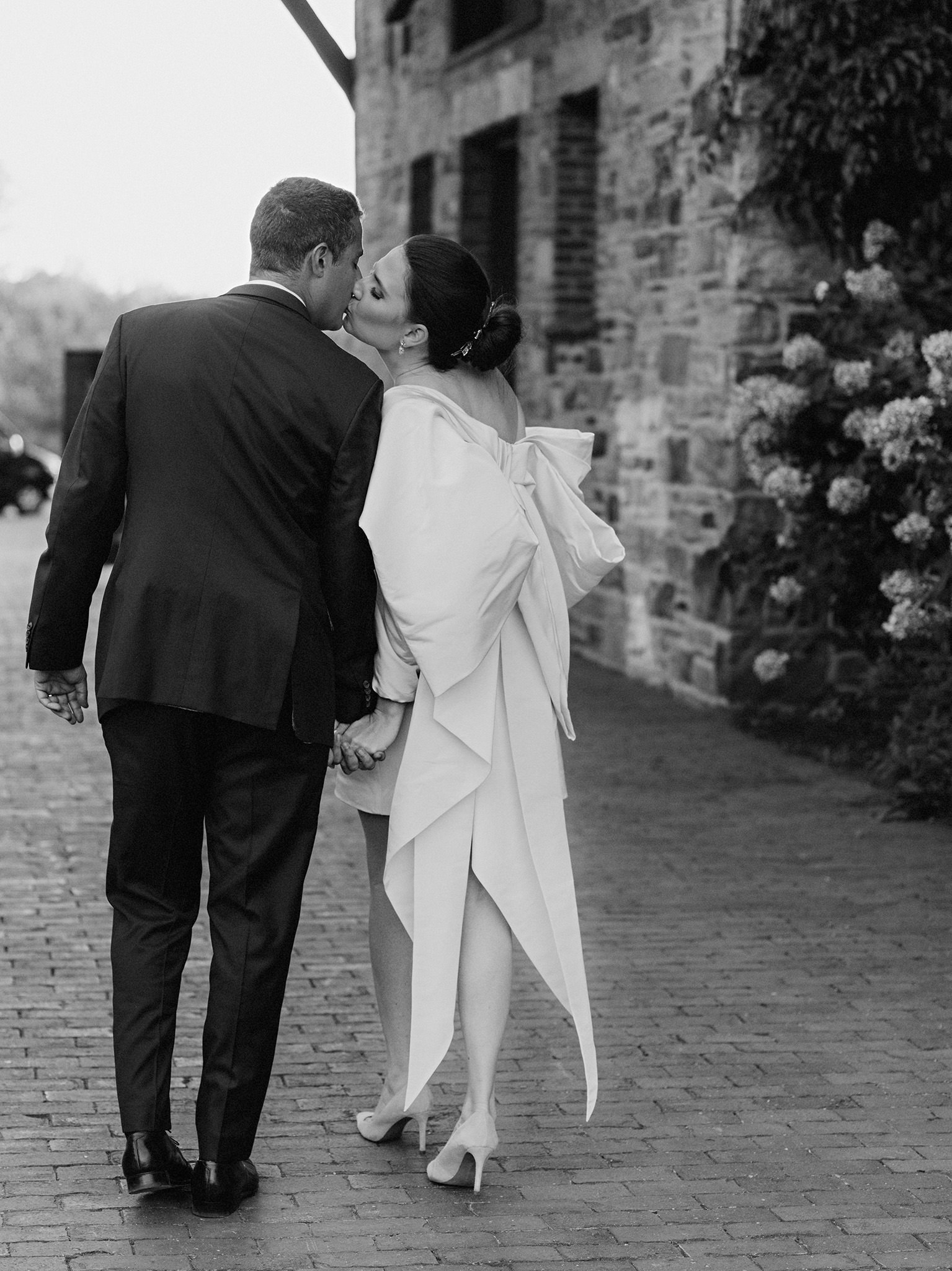 Bride kisses her groom at Blue Hill at Stone barns wearing Carolina Herrera