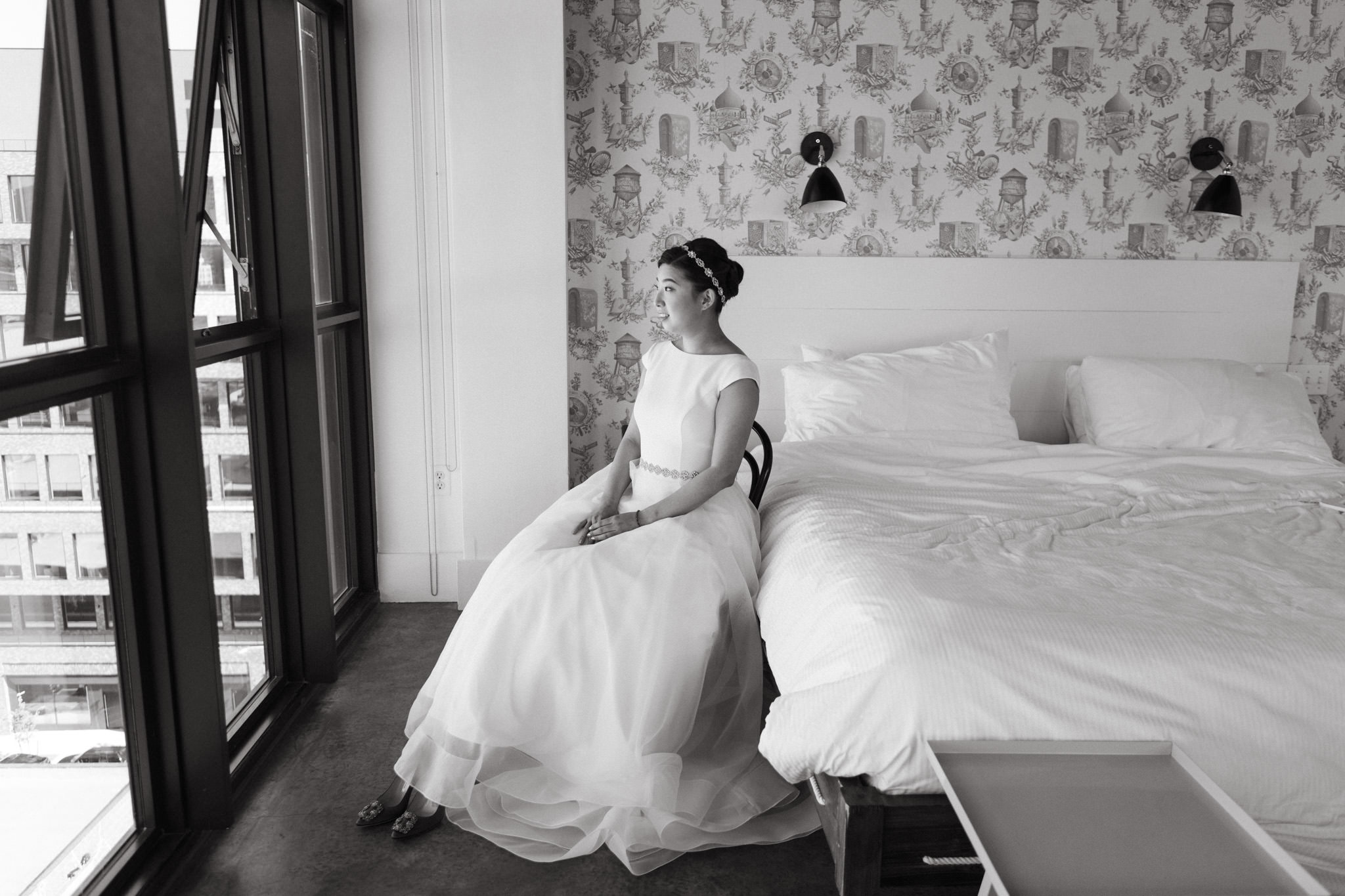 Bride looks out the window on her wedding day