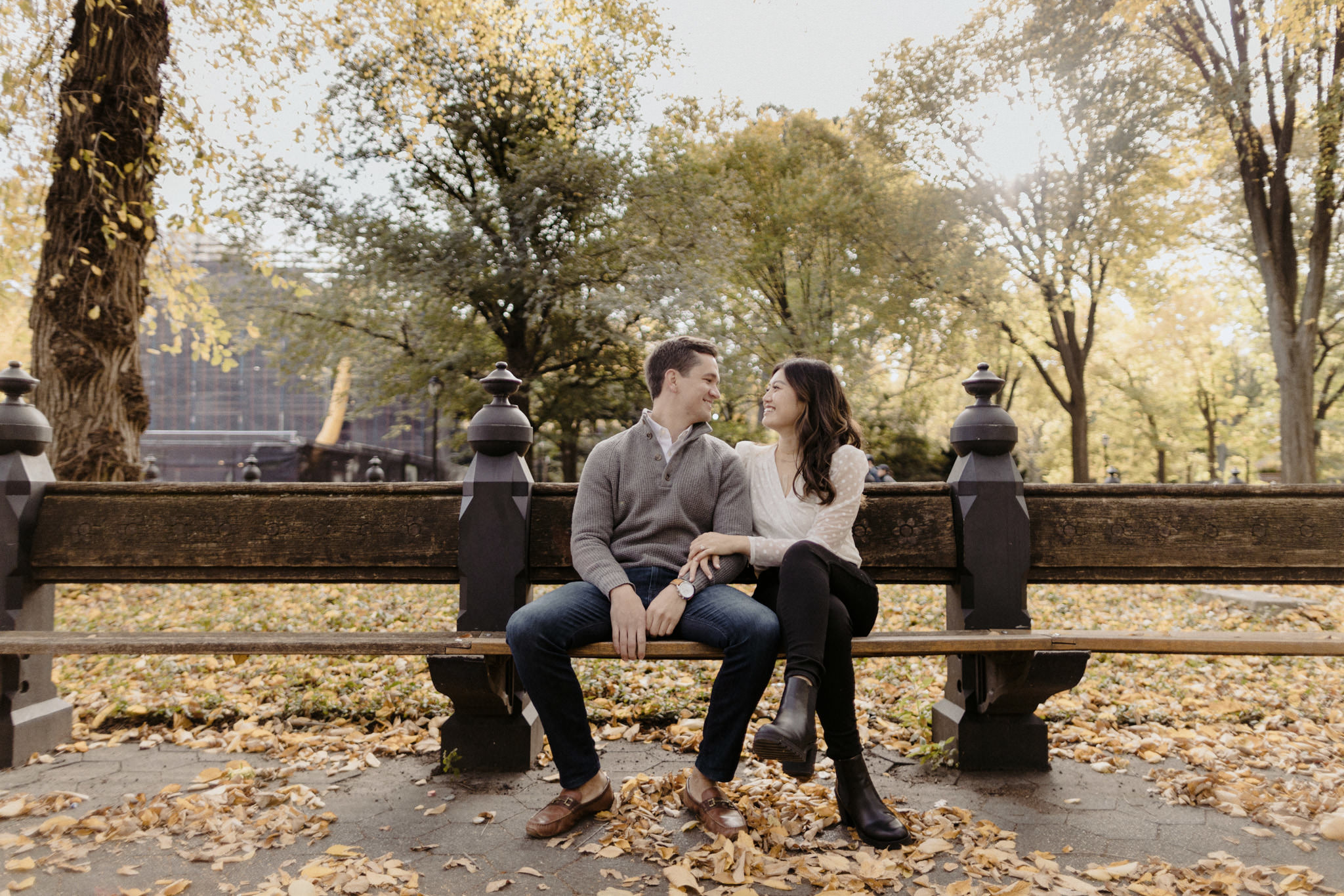 Young couple holding each other on a park bench in Central Park.