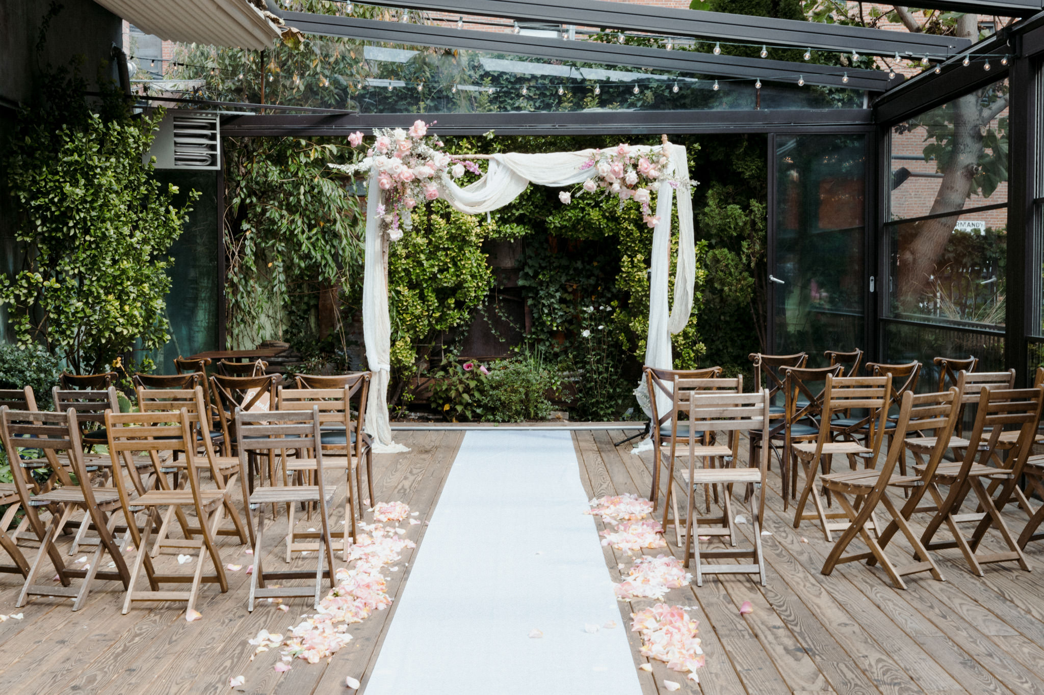 A white altar sprinkled with pink petals in Brooklyn, NY