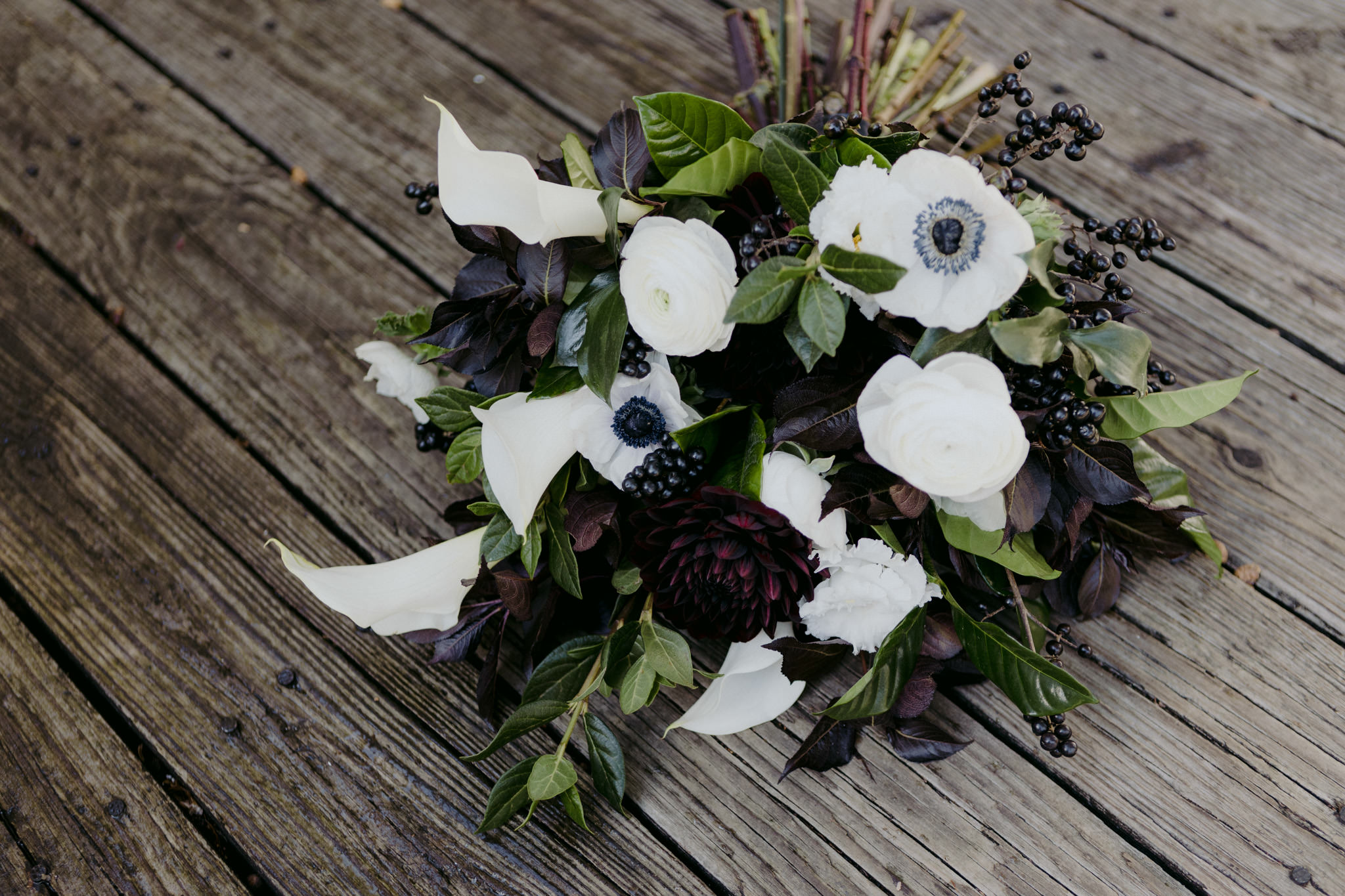 White garden rose bouquet with touches of blue and purple flowers, mixed with greenery