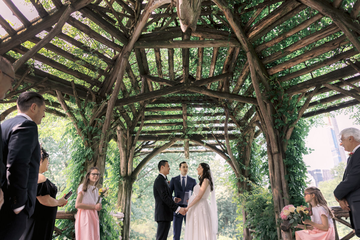 Bride and groom taking their wedding photos in Central Park at Cop Cot