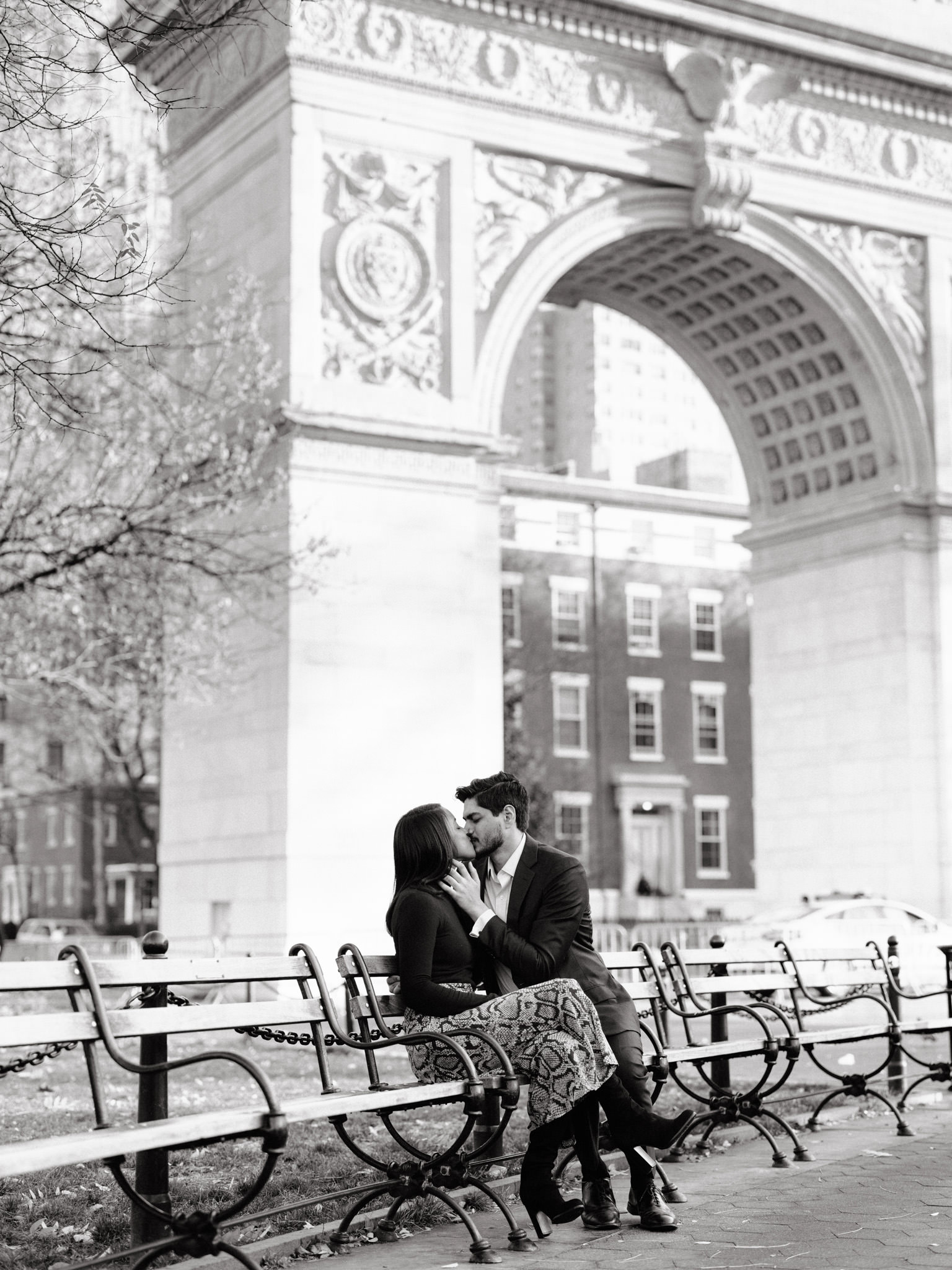 Man and woman kissing on a bench in Washington Square Park