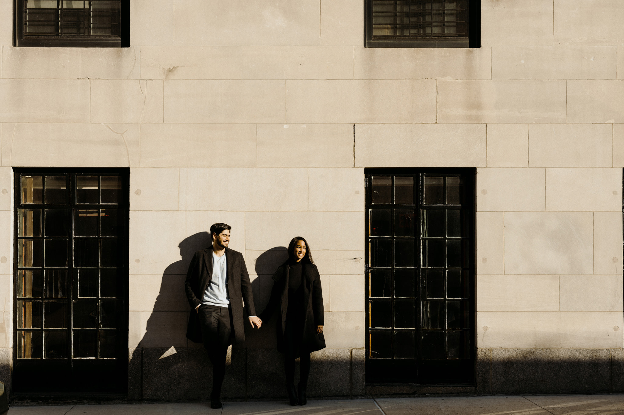 Bi-racial couple leaning against a wall remembering his proposal