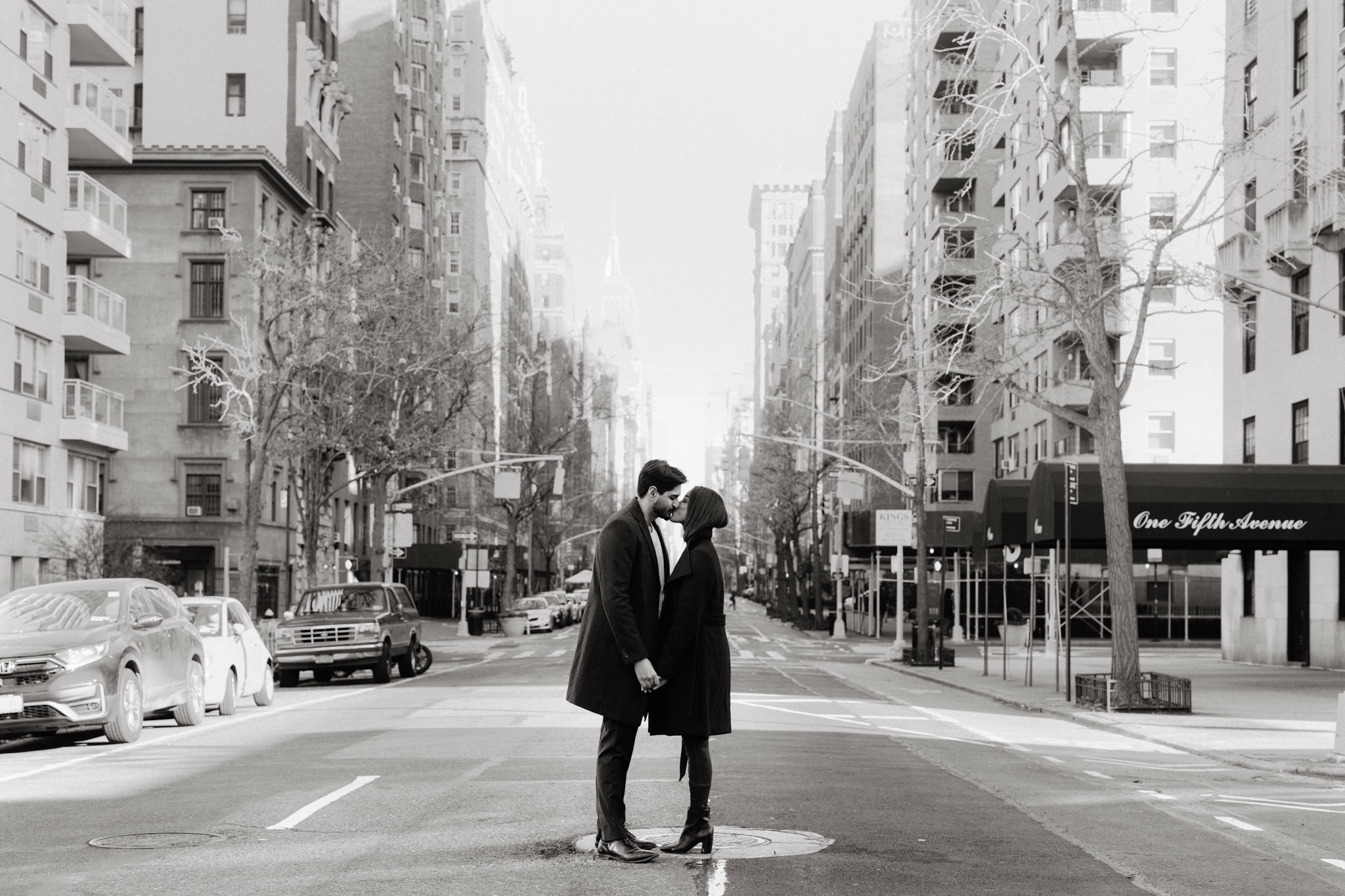 Engaged couple kissing on 5th Ave in NYC
