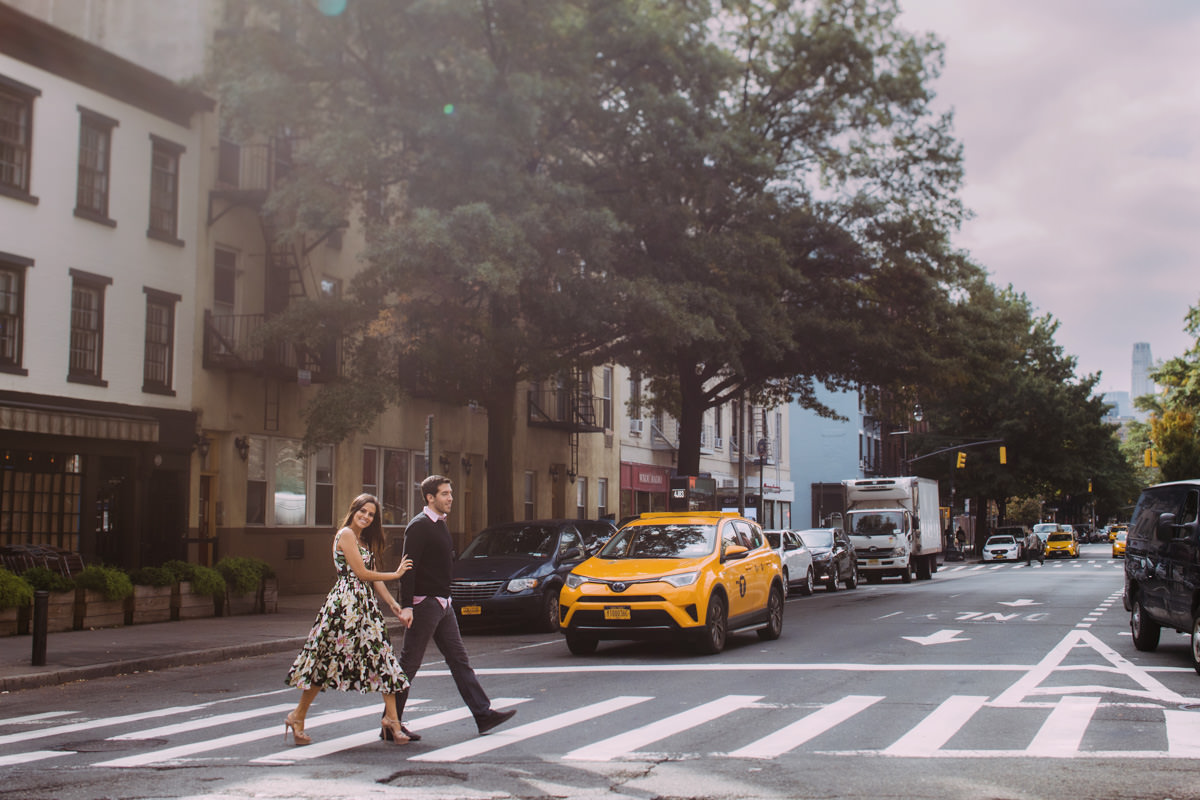 A man and woman walk hand in hand in the West Village of NYC