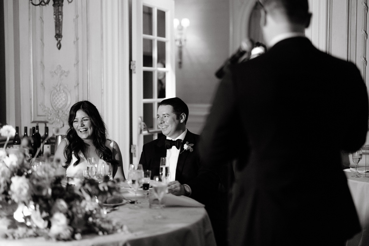 A bride laughs while dining at her wedding reception in the JW Marriott Essex House hotel