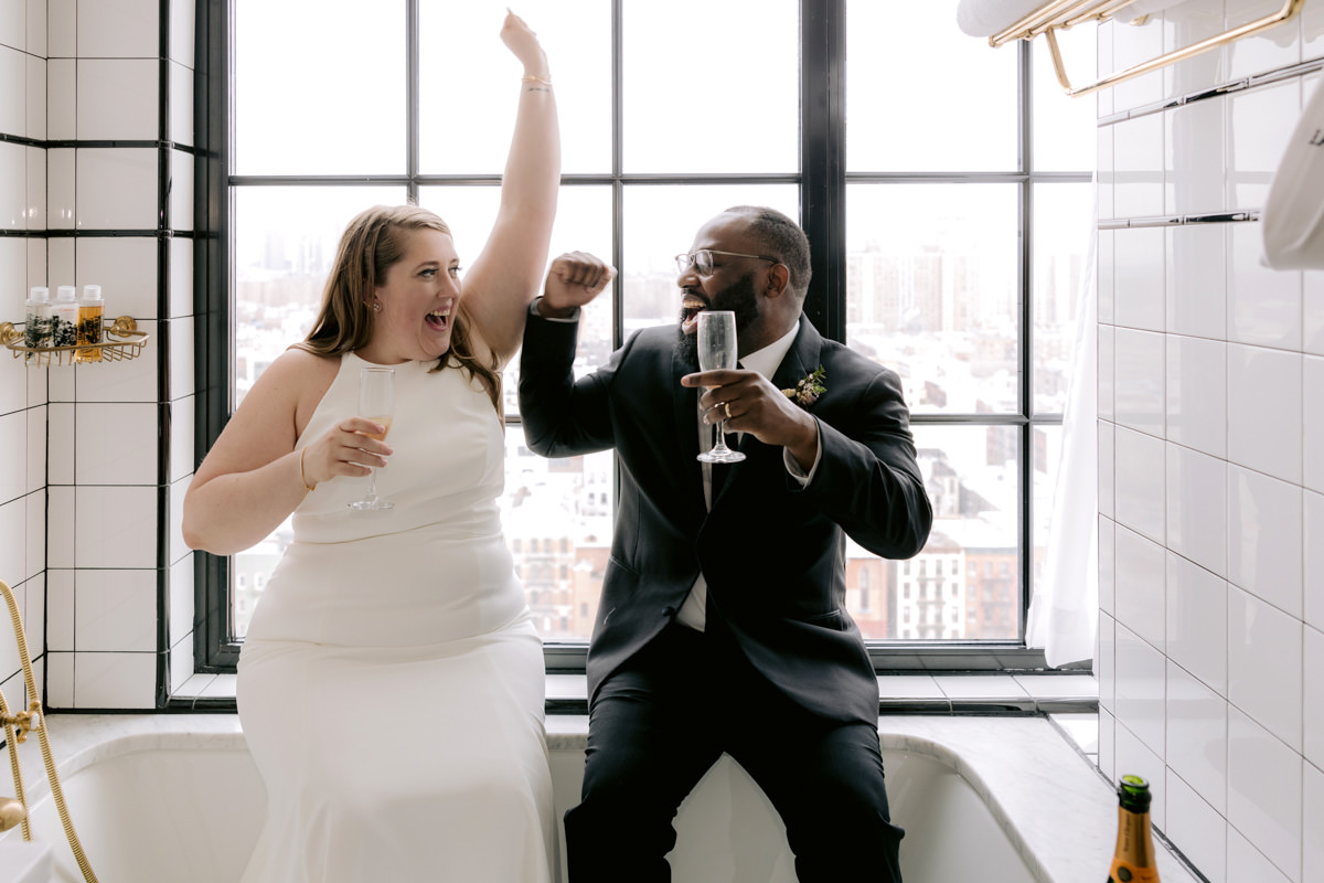 A biracial couple sits in a bathtub at a boutique hotel in Lower Manhattan on their wedding day