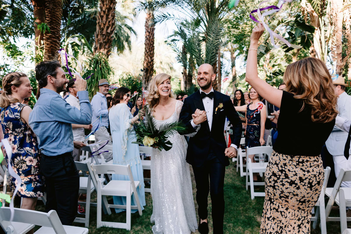 A bride an groom walk down the aisle as their professional wedding photographer captures their descent