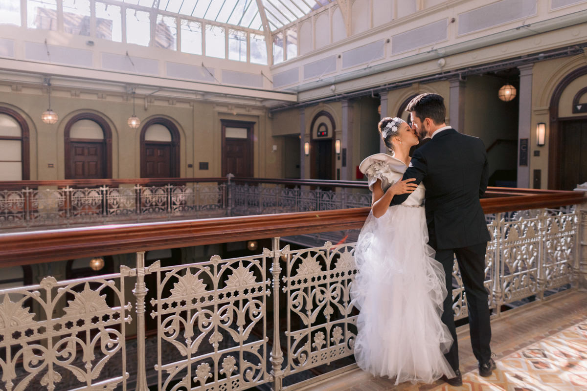 A bride and groom kiss in a stairwell at an iconic Lower Manhattan boutique hotel