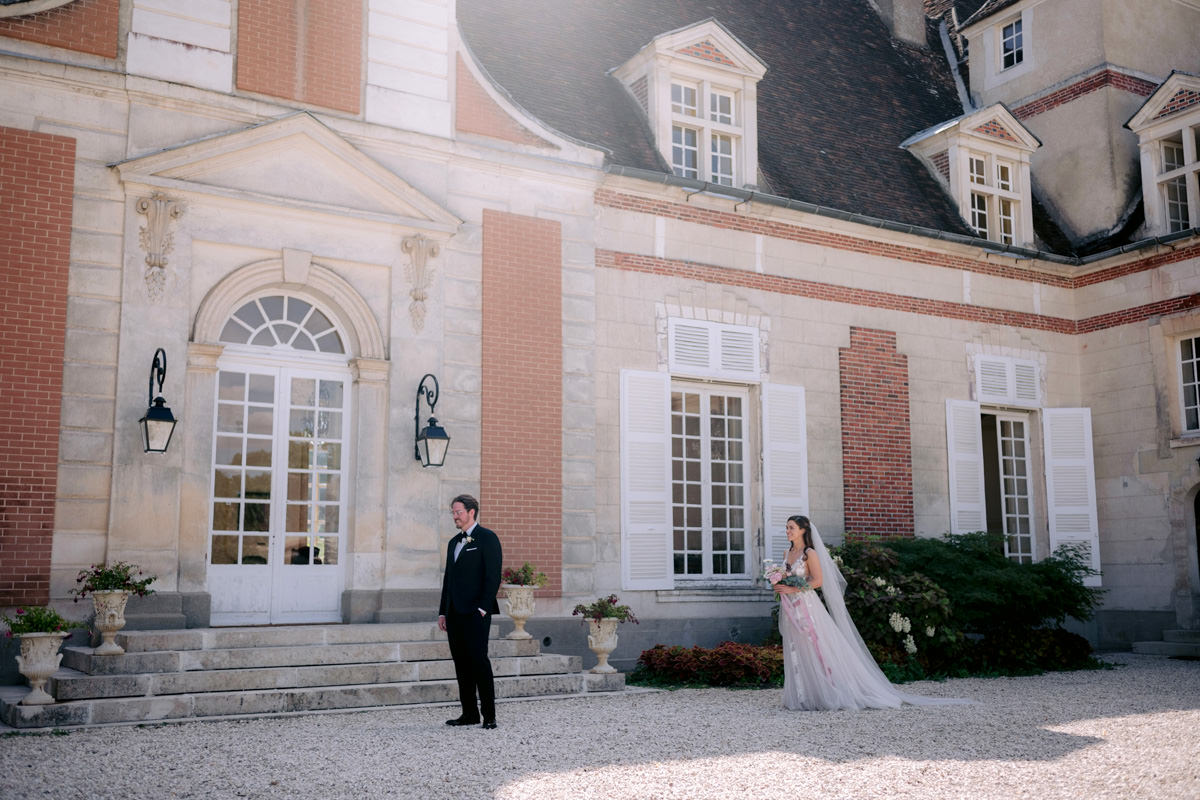 A groom waits for the first look of his bride in France at their destination wedding