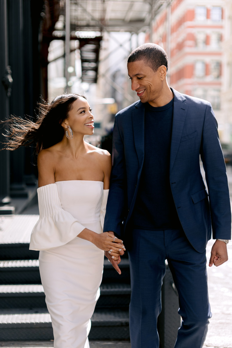 A black bride and groom hold hands in Lower Manhattan
