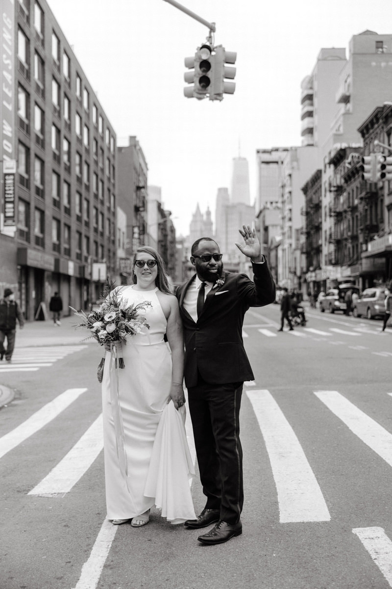 Bride and groom wave to passers-by in the streets of New York City