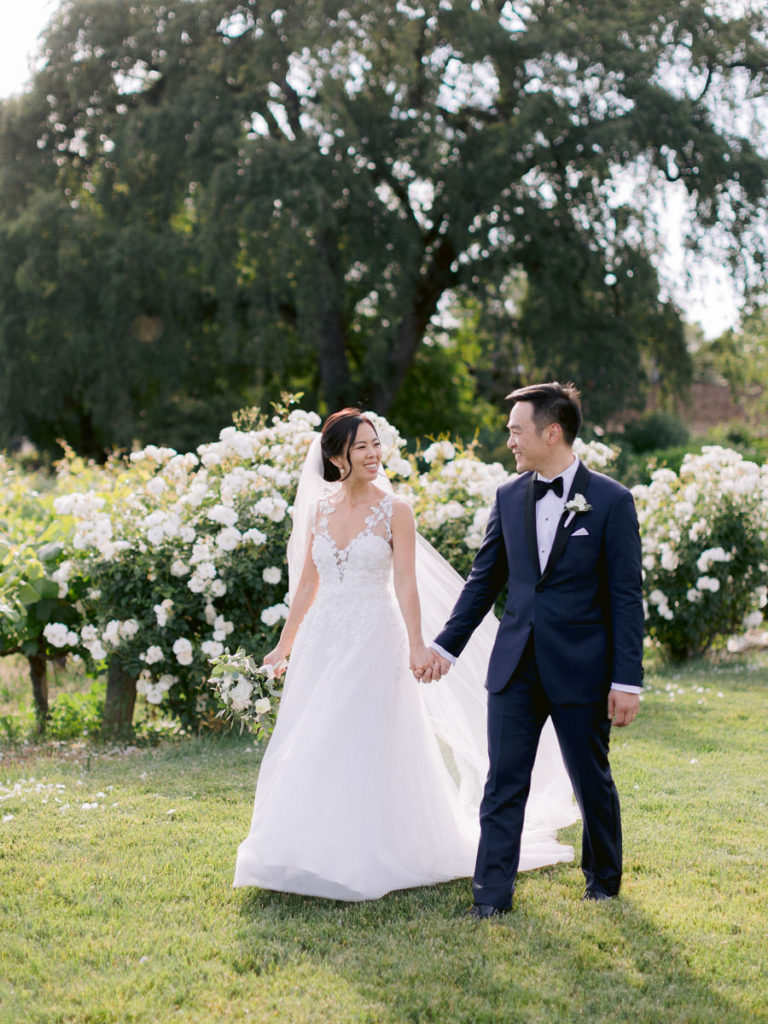 Bride and groom walk hand in hand for their wedding photographer