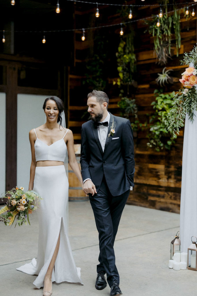 A bride and groom hold hands in Long Island City