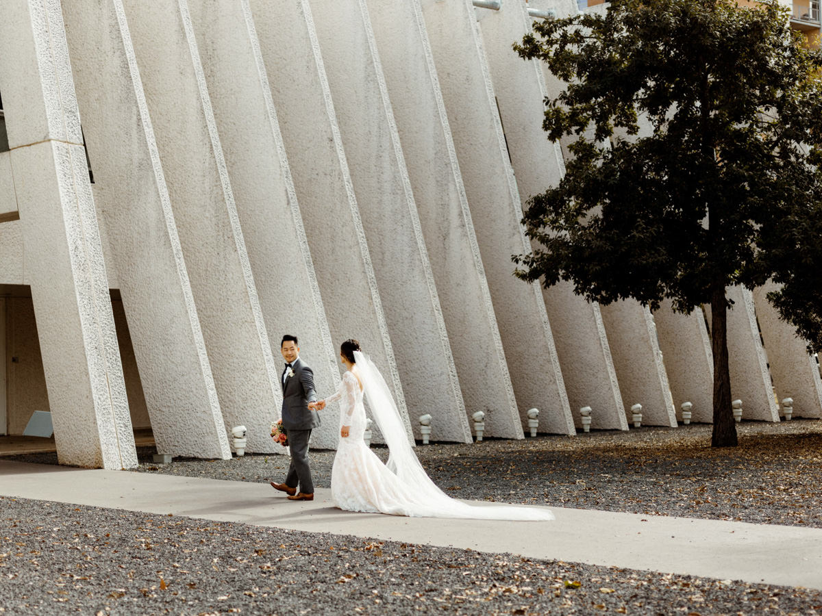 Bride and groom walk hand in hand to their wedding ceremony