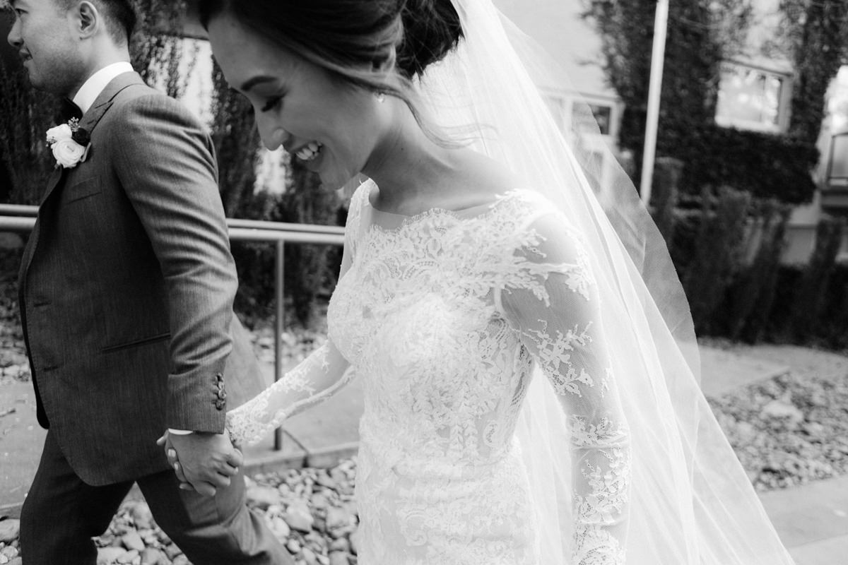 A bride and groom walk with smiles on their faces to their wedding reception