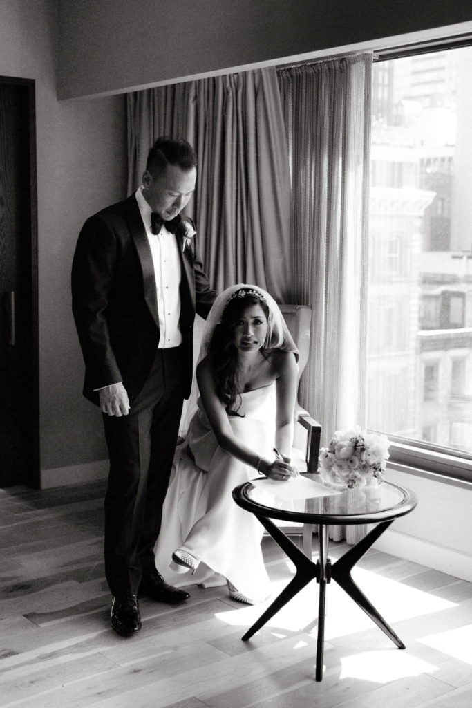 A bride and groom signing their marriage papers