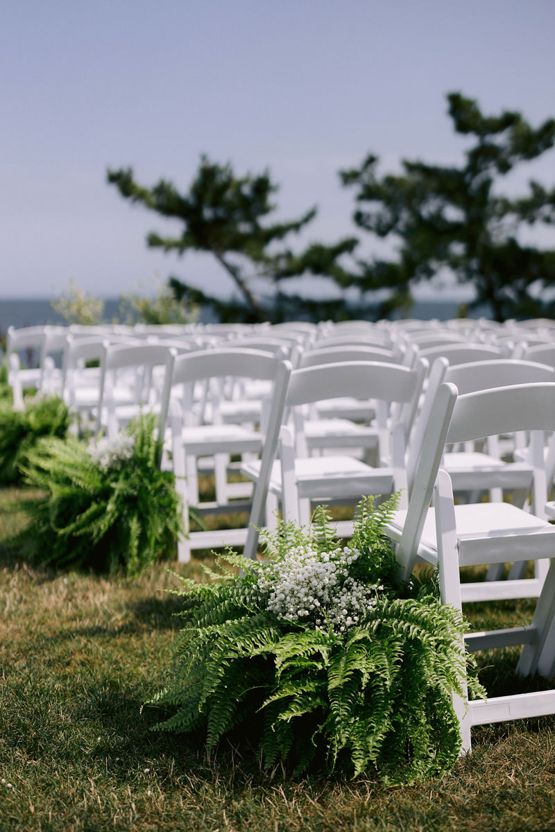 Baby's breath and ferns lining rows of chairs