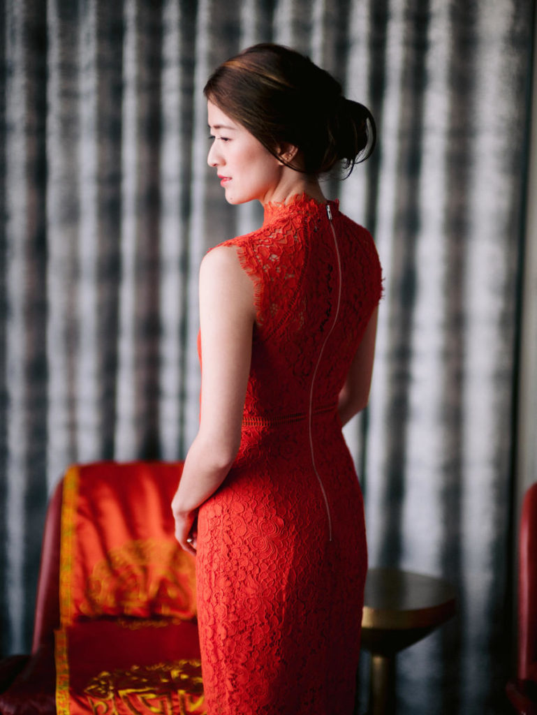 An Asian-American bride wear read and gold on her wedding day