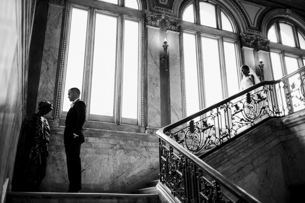 A man stands waiting to see his bride in her wedding dress