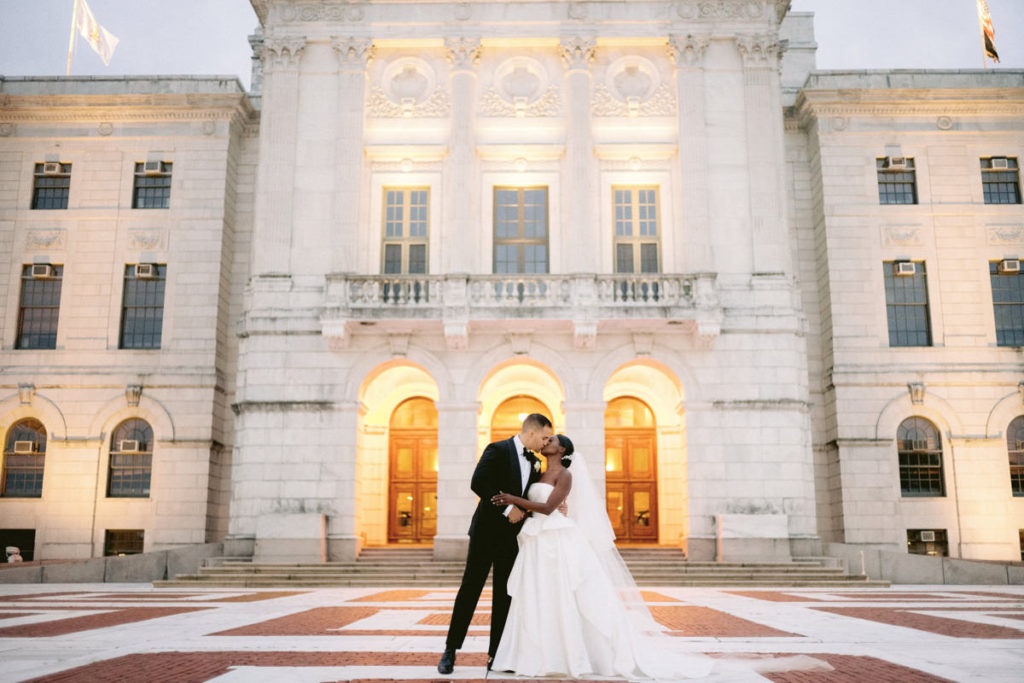 A biracial couple kisses on their wedding day