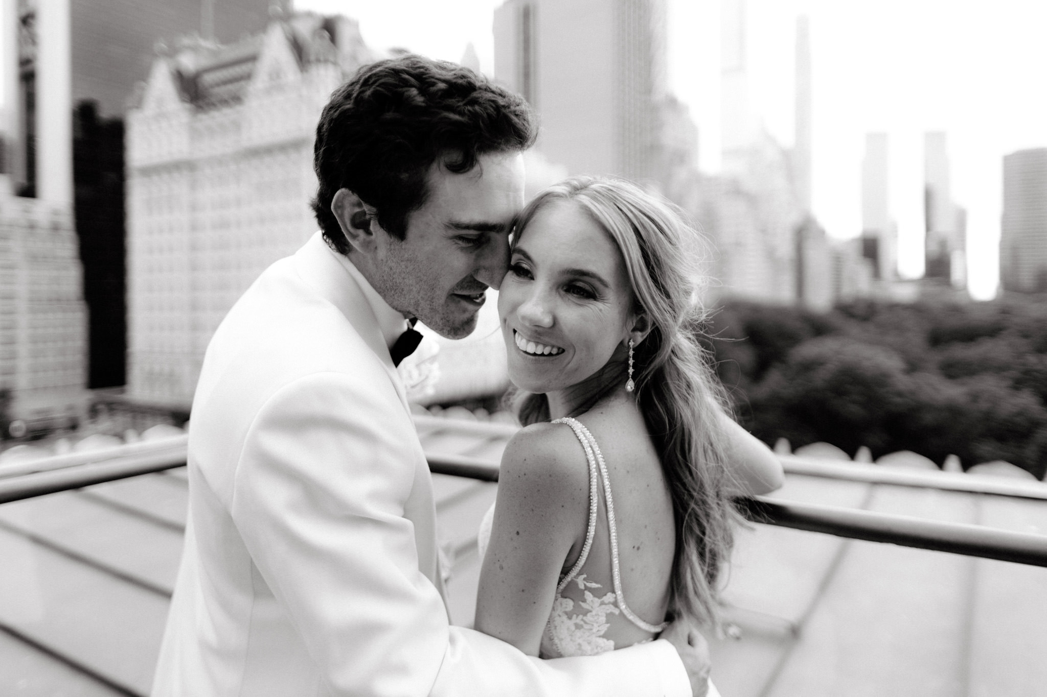 A bride and groom pose for their wedding photographer on a rooftop in New York City